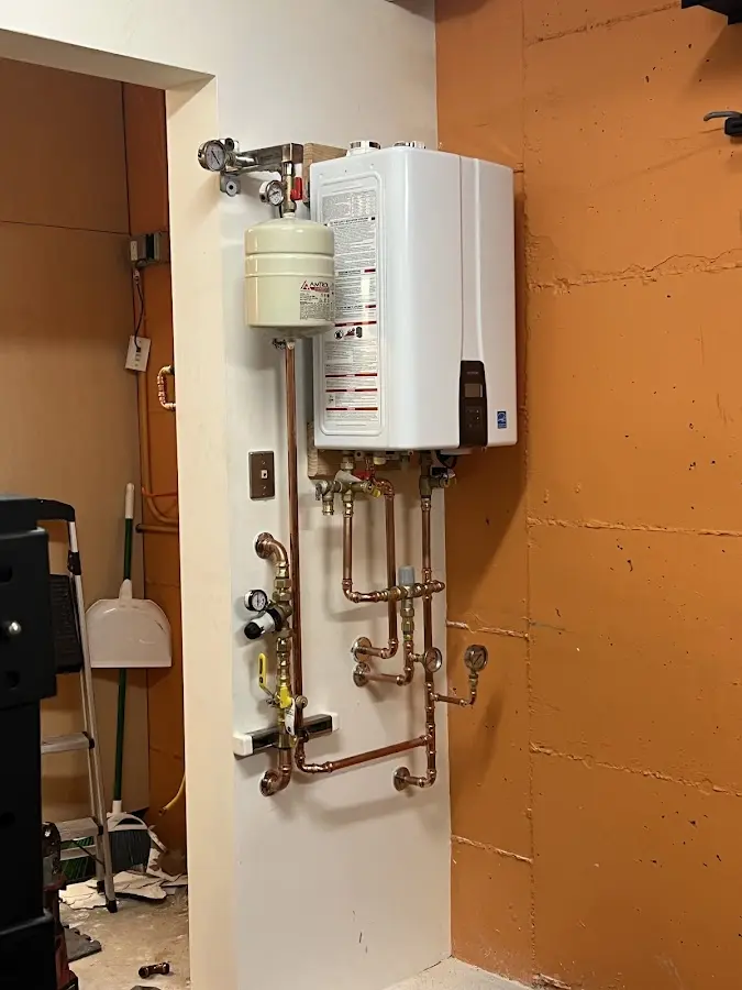 Plumbing technician inspecting water heater connections in Wellington